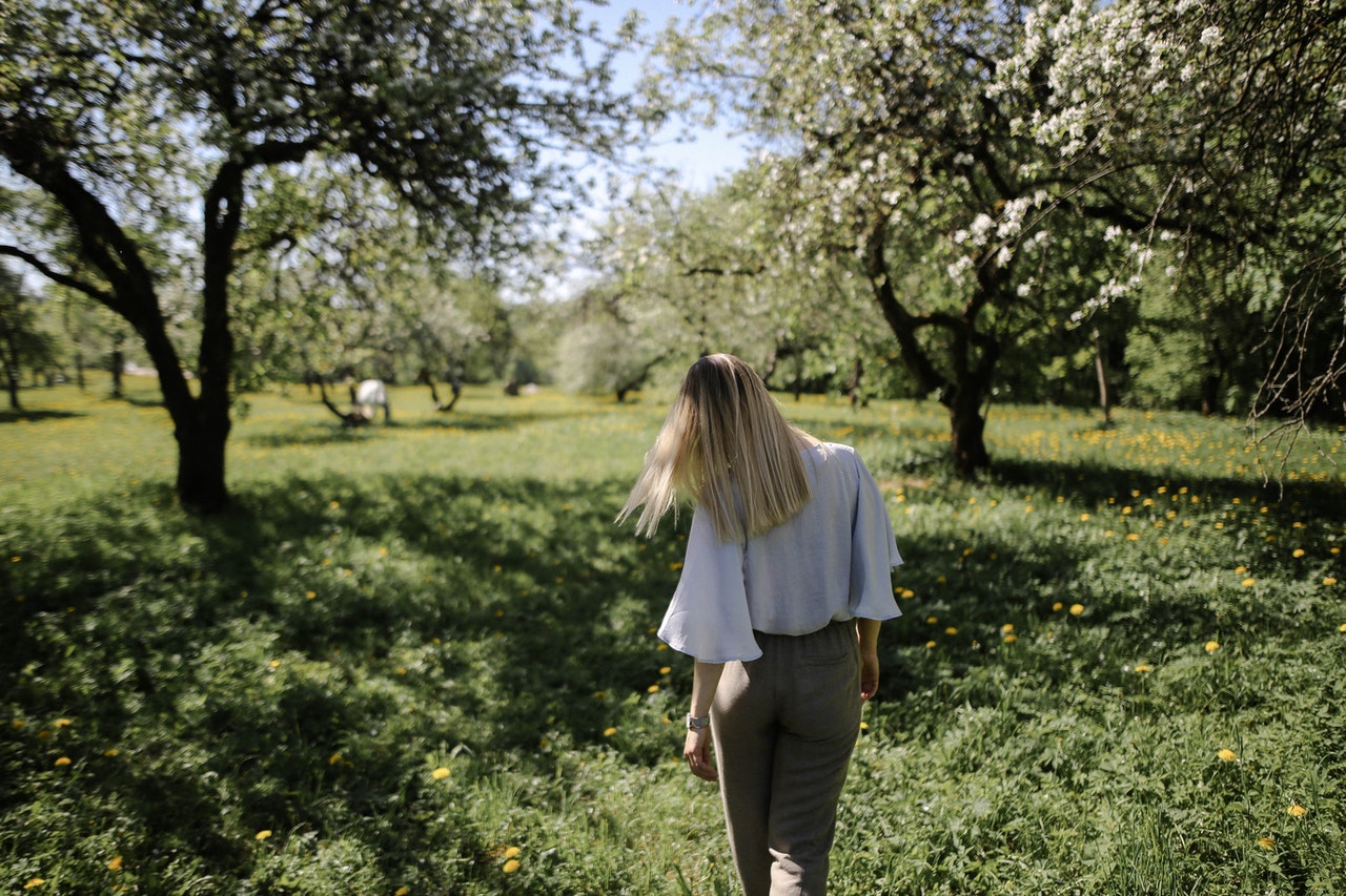 woman walking through flowering trees